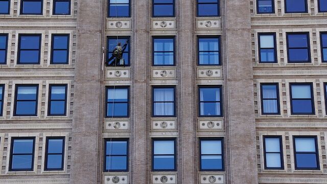 Commercial building with window cleaner cleaning the windows